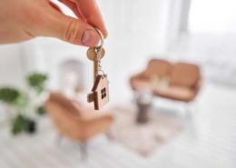 homme tenant une clé et un porte clé de maison dans sa nouvelle propriété