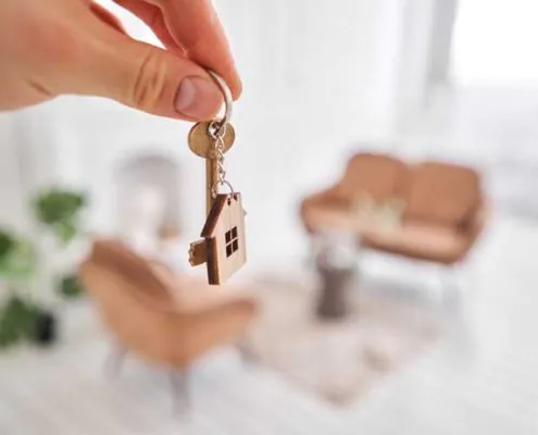 homme tenant une clé et un porte clé de maison dans sa nouvelle propriété